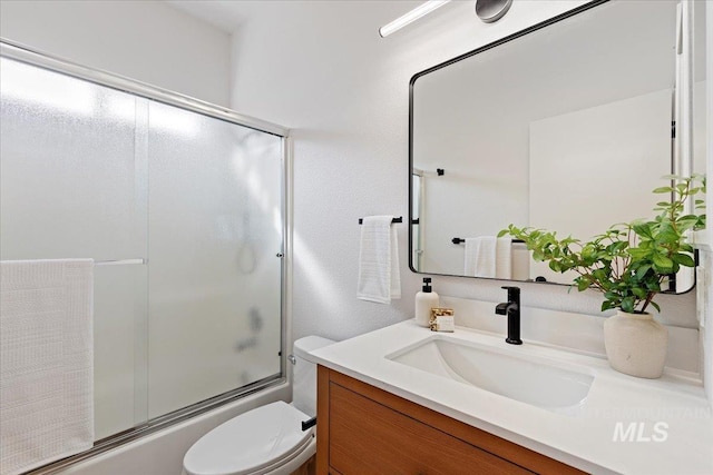 full bathroom with vanity, toilet, and bath / shower combo with glass door