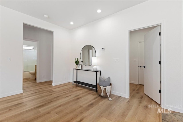 hall featuring light wood finished floors, recessed lighting, and baseboards