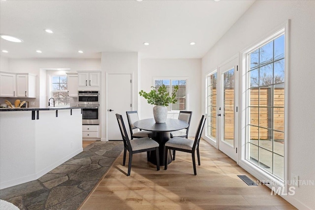 dining room featuring recessed lighting, visible vents, a healthy amount of sunlight, and light wood-type flooring