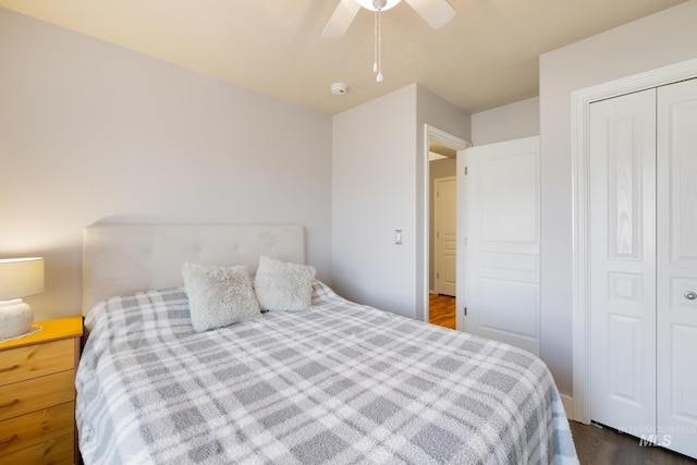 bedroom with dark wood-type flooring, a closet, and ceiling fan