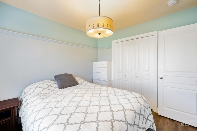 bedroom with dark hardwood / wood-style floors and a closet