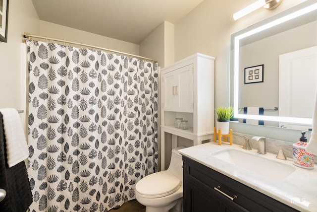 bathroom with walk in shower, vanity, and toilet