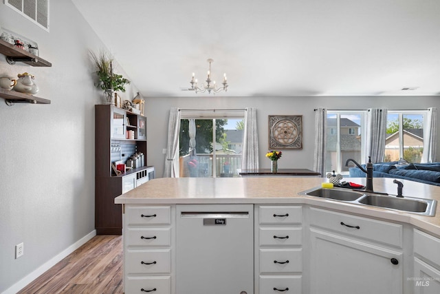 1509 N Cedar St, Jerome, ID 83338 - kitchen featuring dishwashing machine, a chandelier, light wood-style flooring, a sink, and light countertops
