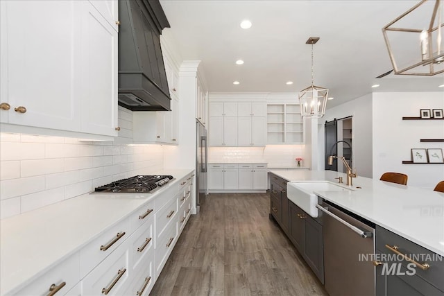 kitchen featuring appliances with stainless steel finishes, white cabinets, a sink, and light countertops