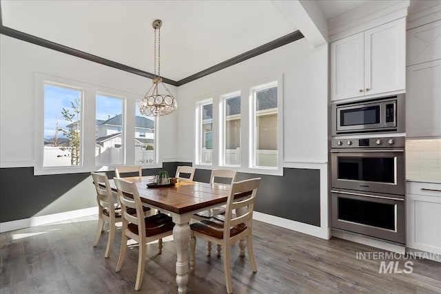 dining area featuring ornamental molding, an inviting chandelier, baseboards, and wood finished floors