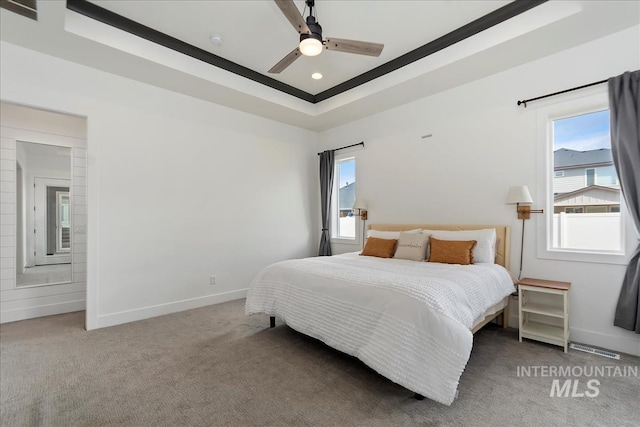 carpeted bedroom with a ceiling fan, recessed lighting, a raised ceiling, and baseboards