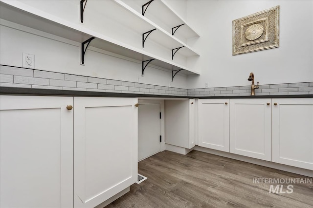 laundry room featuring a sink, wood finished floors, and visible vents