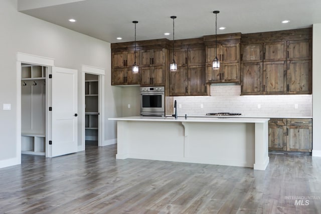 275 Meadow View Dr, Payette, ID 83661 - kitchen featuring stainless steel oven, backsplash, light countertops, an island with sink, and recessed lighting