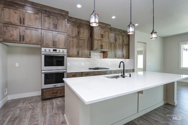 275 Meadow View Dr, Payette, ID 83661 - kitchen with appliances with stainless steel finishes, wood finished floors, backsplash, a center island with sink, and recessed lighting