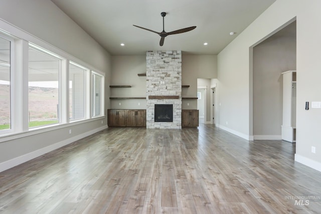 275 Meadow View Dr, Payette, ID 83661 - unfurnished living room with ceiling fan, wood finished floors, a stone fireplace, recessed lighting, and a towering ceiling