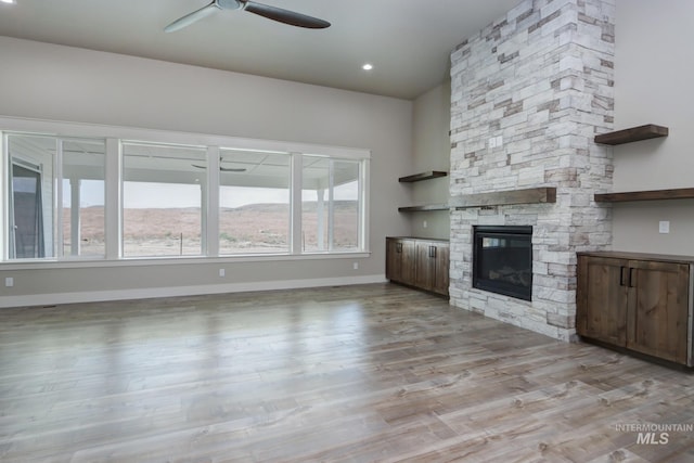 275 Meadow View Dr, Payette, ID 83661 - unfurnished living room with a ceiling fan, light wood-style flooring, and a stone fireplace