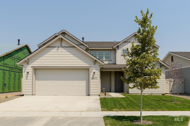 view of front of home with board and batten siding, a front yard, concrete driveway, and an attached garage