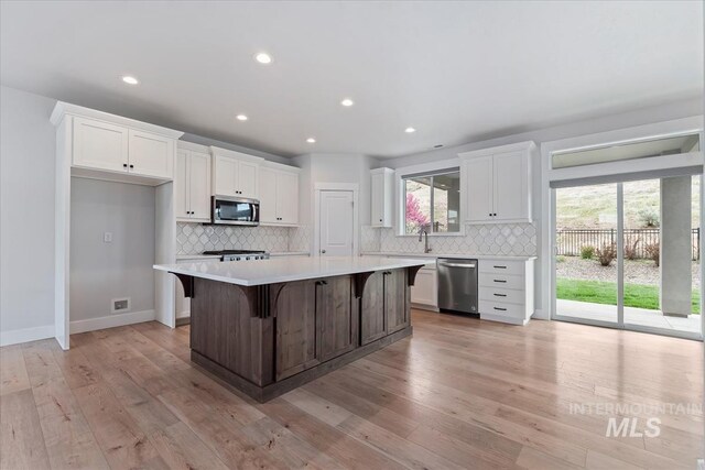 19322 N Shepherds Pie Pl, Boise, ID 83714 - kitchen featuring appliances with stainless steel finishes, white cabinets, light countertops, backsplash, and recessed lighting