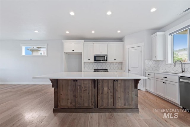 19322 N Shepherds Pie Pl, Boise, ID 83714 - kitchen featuring appliances with stainless steel finishes, a sink, a kitchen island, white cabinets, and recessed lighting