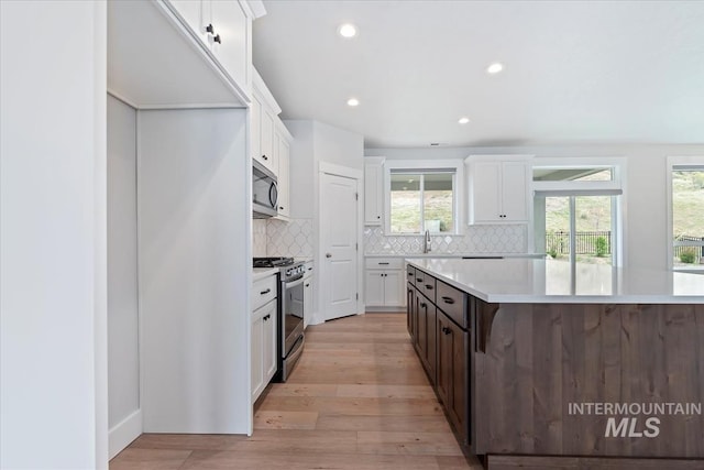 19322 N Shepherds Pie Pl, Boise, ID 83714 - kitchen with stainless steel appliances, white cabinetry, light countertops, decorative backsplash, and recessed lighting