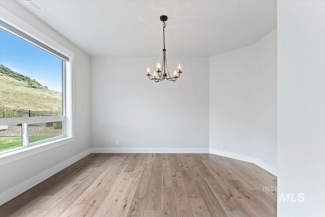 19322 N Shepherds Pie Pl, Boise, ID 83714 - unfurnished room featuring a chandelier, plenty of natural light, light wood finished floors, and baseboards