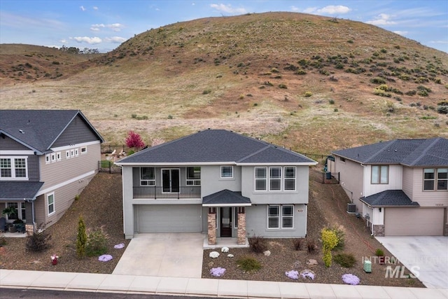 19322 N Shepherds Pie Pl, Boise, ID 83714 - view of front of home with concrete driveway, stucco siding, an attached garage, a mountain view, and a balcony