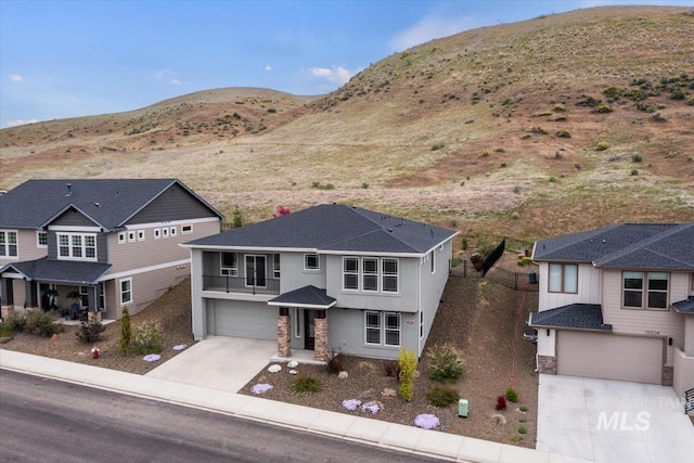 19322 N Shepherds Pie Pl, Boise, ID 83714 - view of front of property featuring an attached garage, concrete driveway, a balcony, a mountain view, and stucco siding
