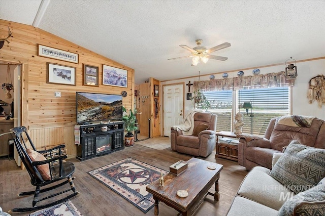 103 W 420 N, Shoshone, ID 83352 - living room with wooden walls, lofted ceiling, a glass covered fireplace, ceiling fan, and a textured ceiling