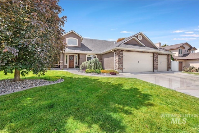 1021 Ballard Ln, Kimberly, ID 83341 - view of front of home featuring a front yard, a garage, concrete driveway, stone siding, and roof with shingles