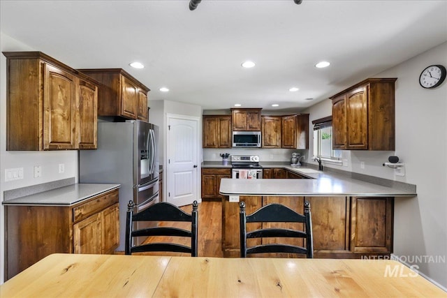 1021 Ballard Ln, Kimberly, ID 83341 - kitchen with appliances with stainless steel finishes, recessed lighting, a peninsula, a kitchen breakfast bar, and light countertops
