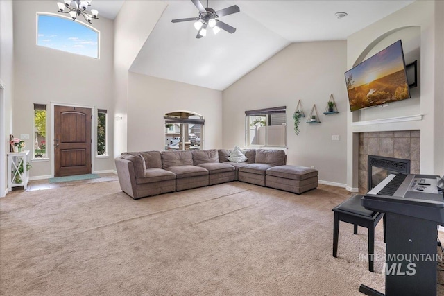 1021 Ballard Ln, Kimberly, ID 83341 - living room with high vaulted ceiling, carpet flooring, a ceiling fan, a tiled fireplace, and a chandelier