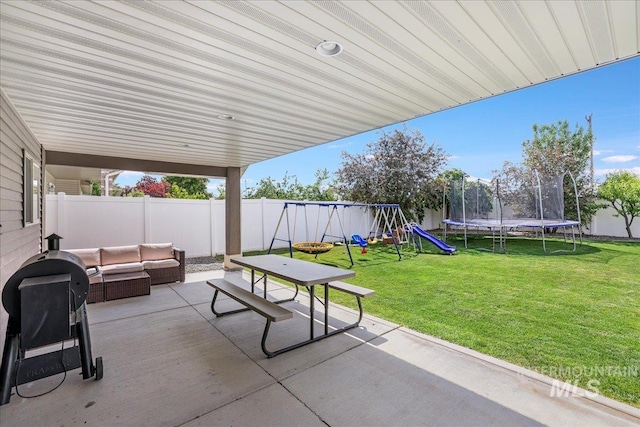 1021 Ballard Ln, Kimberly, ID 83341 - fenced backyard featuring a trampoline, a patio area, a playground, an outdoor living space, and area for grilling
