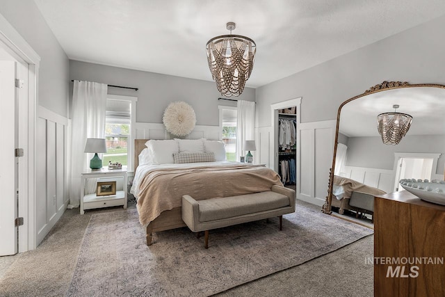 carpeted bedroom featuring a chandelier, a closet, a spacious closet, and multiple windows