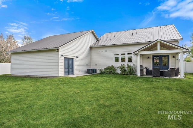 rear view of property with french doors, central air condition unit, and a lawn