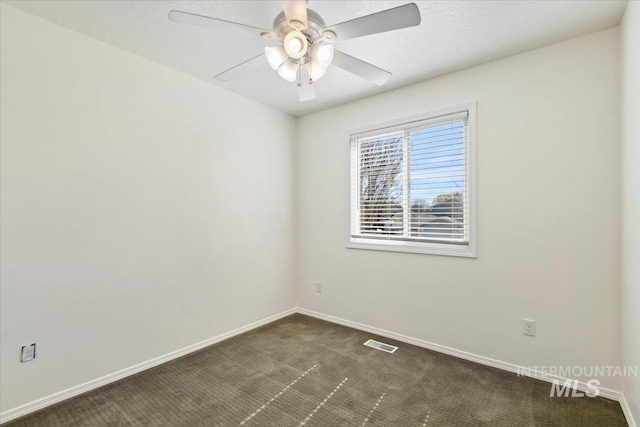 unfurnished room featuring baseboards, visible vents, ceiling fan, and dark carpet