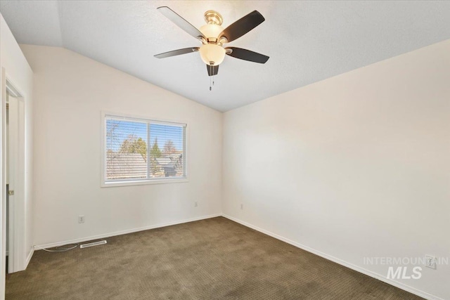 unfurnished room with baseboards, dark carpet, vaulted ceiling, and ceiling fan