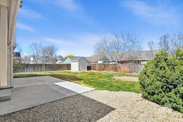 view of yard with a fenced backyard, an outbuilding, a shed, and a patio