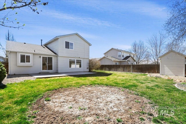 rear view of house featuring fence, a storage unit, an outbuilding, a yard, and a patio area