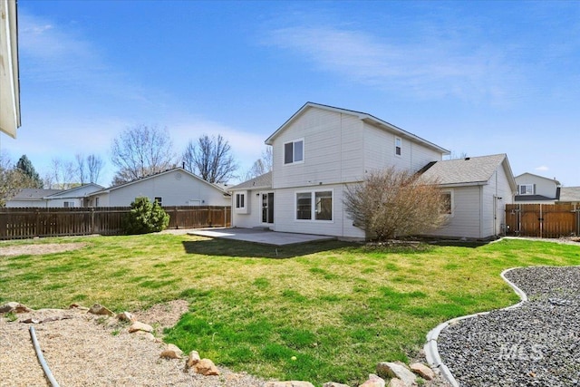 rear view of house with a patio, a fenced backyard, and a lawn
