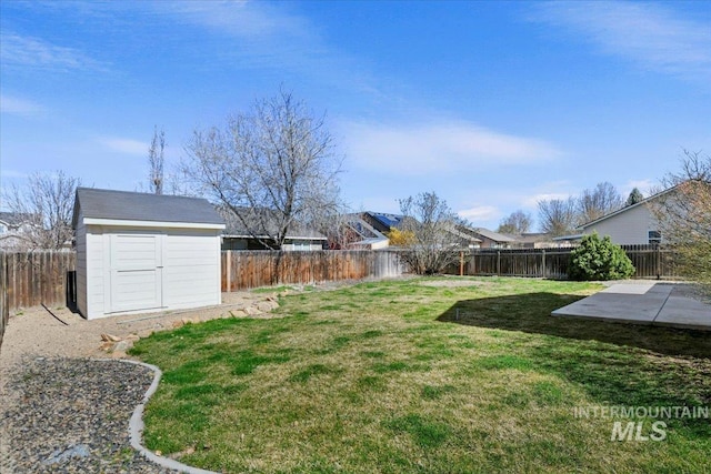 view of yard with a fenced backyard, a patio, an outbuilding, and a storage shed