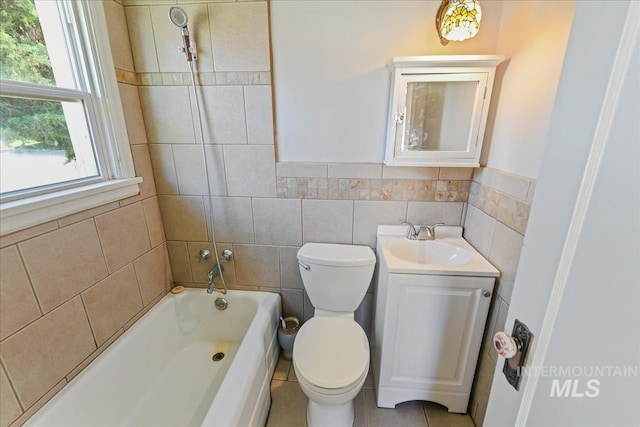 404 W 5th St, Weiser, ID 83672 - bathroom featuring toilet, vanity, tile walls, shower / bathtub combination, and a wainscoted wall