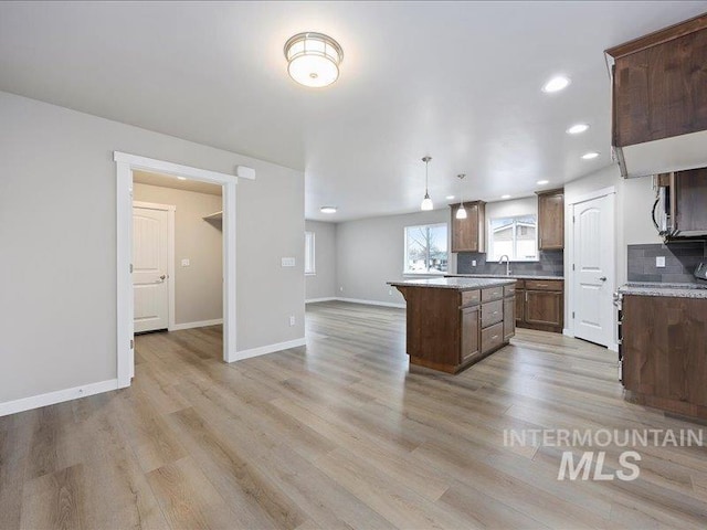 1308 N Buchanan Unit A & B, Jerome, ID 83338 - kitchen with a center island, light wood-style flooring, light countertops, decorative backsplash, and recessed lighting