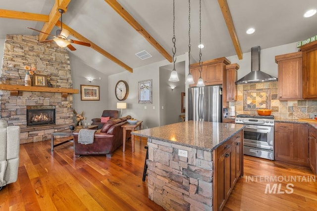 1391 Greystone Dr, Mccall, ID 83638 - kitchen featuring appliances with stainless steel finishes, wall chimney exhaust hood, open floor plan, ceiling fan, and light wood finished floors