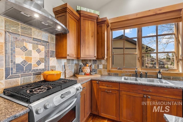1391 Greystone Dr, Mccall, ID 83638 - kitchen featuring stainless steel gas range, wall chimney exhaust hood, brown cabinets, a sink, and decorative backsplash