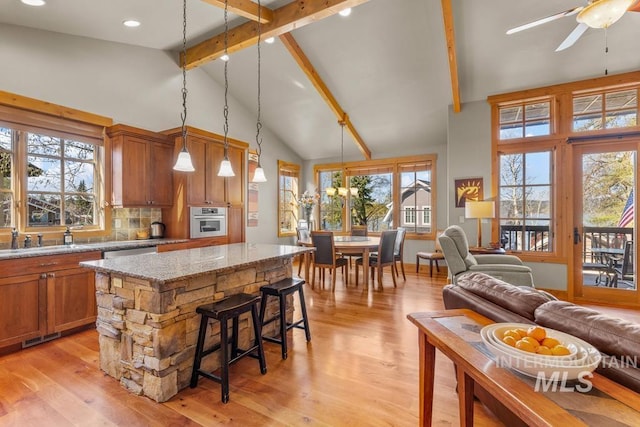 1391 Greystone Dr, Mccall, ID 83638 - kitchen featuring appliances with stainless steel finishes, beam ceiling, light wood-type flooring, a sink, and brown cabinetry