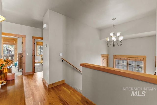 1391 Greystone Dr, Mccall, ID 83638 - hall featuring an upstairs landing, light wood finished floors, a chandelier, and baseboards