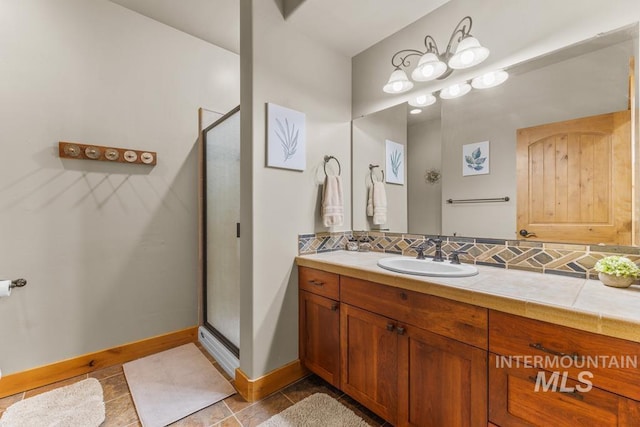 1391 Greystone Dr, Mccall, ID 83638 - full bath with a shower stall, baseboards, vanity, tile patterned floors, and decorative backsplash
