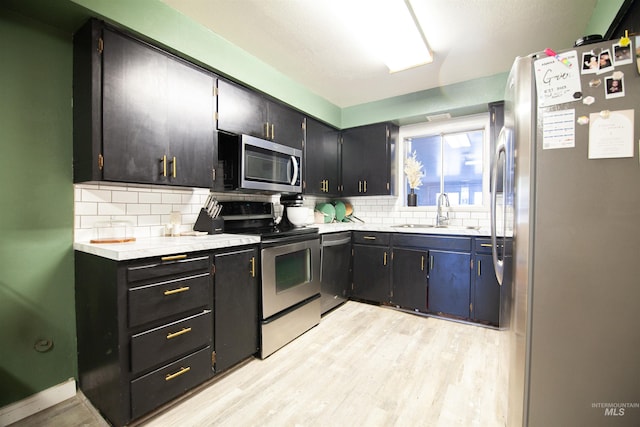 611 E Hawaii Ave, Nampa, ID 83686 - kitchen with appliances with stainless steel finishes, decorative backsplash, light countertops, light wood-style flooring, and dark cabinetry
