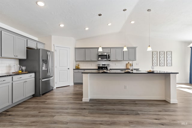 17032 N Thomas Paine Way, Nampa, ID 83687 - kitchen featuring stainless steel appliances, gray cabinets, dark countertops, tasteful backsplash, and lofted ceiling