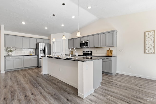 17032 N Thomas Paine Way, Nampa, ID 83687 - kitchen with stainless steel appliances, gray cabinetry, light wood-style flooring, backsplash, and lofted ceiling