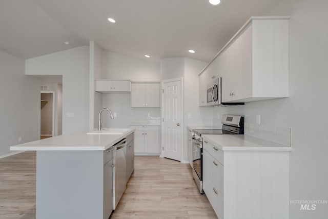 kitchen featuring stainless steel appliances, light countertops, white cabinets, a kitchen island with sink, and a sink