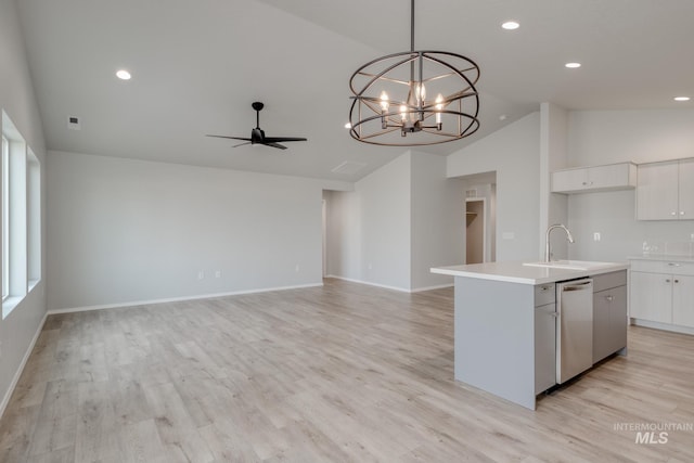 kitchen featuring dishwasher, a kitchen island with sink, light countertops, white cabinetry, and a sink