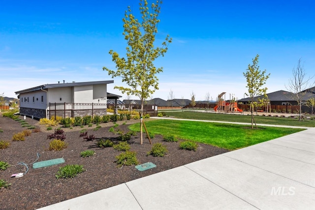 view of yard featuring playground community and fence
