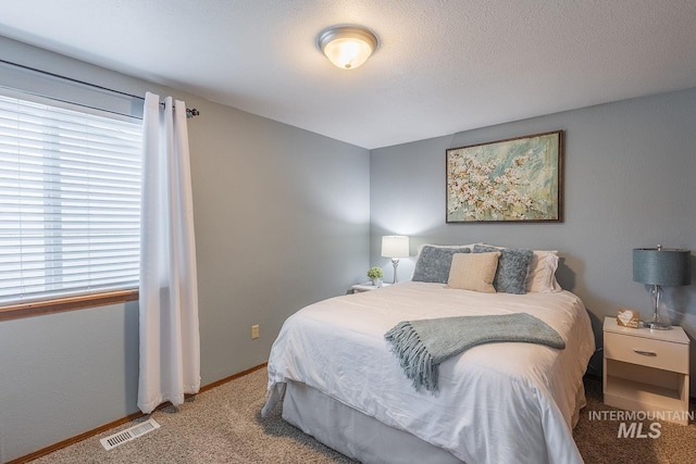 bedroom featuring visible vents, baseboards, carpet floors, and multiple windows