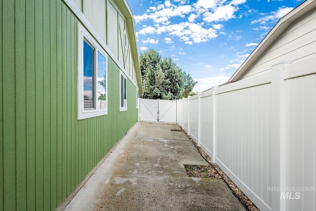 view of side of home with a patio area and fence